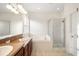 Bathroom with dual sinks, granite countertop, tub, and glass-enclosed shower at 14648 Bournemouth Rd, Tampa, FL 33626