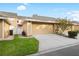 Attached two-car garage with neutral paint, manicured lawn, and brick paver sidewalk on a sunny day at 14648 Bournemouth Rd, Tampa, FL 33626
