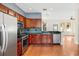 Open kitchen featuring modern appliances, sleek countertops, and wood flooring at 14648 Bournemouth Rd, Tampa, FL 33626