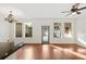Spacious living room with hardwood floors, large windows, and modern ceiling fan at 14648 Bournemouth Rd, Tampa, FL 33626