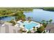 Aerial view of a community pool with palm trees, umbrellas and a lake in the background at 14648 Bournemouth Rd, Tampa, FL 33626