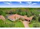 Aerial view of sprawling home with tile roof, screened pool, and lush landscaping at 14910 Tom Fazio Ct, Tampa, FL 33626