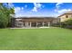 Expansive backyard with a screened lanai featuring lounge chairs and fire bowls at 14910 Tom Fazio Ct, Tampa, FL 33626