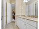 Well-lit bathroom featuring a double vanity with granite countertops and white cabinets at 14910 Tom Fazio Ct, Tampa, FL 33626