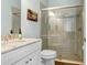 Updated bathroom showcasing a tiled shower with glass door, granite vanity top, and modern fixtures at 14910 Tom Fazio Ct, Tampa, FL 33626