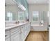 Bathroom features a large soaking tub and a double sink vanity with a white marble countertop at 14910 Tom Fazio Ct, Tampa, FL 33626