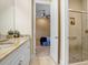 Bathroom view showcasing a granite countertop vanity, open door, and glass-enclosed shower at 14910 Tom Fazio Ct, Tampa, FL 33626