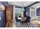 Dining room featuring blue walls, wood floors, a statement light fixture, and modern accents at 14910 Tom Fazio Ct, Tampa, FL 33626