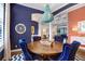 Elegant dining room with a wooden table, blue velvet chairs, and unique blue chandelier at 14910 Tom Fazio Ct, Tampa, FL 33626