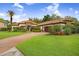 A charming one-story home with a red tile roof, stone accents, lush landscaping and a brick driveway leading to a two-car garage at 14910 Tom Fazio Ct, Tampa, FL 33626