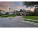 A picturesque home at sunset featuring a paver driveway, manicured lawn, mature palm trees, and a two-car garage at 14910 Tom Fazio Ct, Tampa, FL 33626