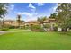 A well-maintained home featuring a spacious front lawn and manicured landscaping with mature palm trees and tasteful shrubbery at 14910 Tom Fazio Ct, Tampa, FL 33626