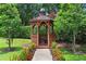 Charming gazebo nestled in a garden setting with flowering plants and mature trees at 14910 Tom Fazio Ct, Tampa, FL 33626