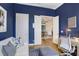 Home office with blue walls, hardwood floors, and French doors opening to the living room at 14910 Tom Fazio Ct, Tampa, FL 33626