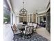 Covered patio features an outdoor dining area with a modern light fixture and a view into the living room at 14910 Tom Fazio Ct, Tampa, FL 33626