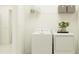 Clean laundry room with white appliances and overhead storage shelving at 18473 Serene Lake Loop, Lutz, FL 33548