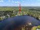 Aerial view with arrow highlighting home within serene waterfront community with beautiful trees and lake access at 18712 Lakeshore Dr, Lutz, FL 33549