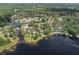 Aerial view of a waterfront community with mature trees, showcasing the neighborhood's serene setting at 18712 Lakeshore Dr, Lutz, FL 33549