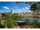 Beautiful backyard view of canal and blue boat under sunny skies, highlighting waterfront living at 18712 Lakeshore Dr, Lutz, FL 33549