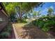 Tranquil backyard with lush greenery, pond view, and a wooden playset beneath mature trees at 18712 Lakeshore Dr, Lutz, FL 33549