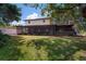 Backyard of home features a large screened in porch and mature trees at 18712 Lakeshore Dr, Lutz, FL 33549