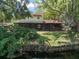 View of backyard with screened in porch overlooking the tranquil waterfront at 18712 Lakeshore Dr, Lutz, FL 33549