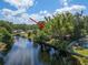 View of waterfront home with arrow, showcasing lush backyard and canal access at 18712 Lakeshore Dr, Lutz, FL 33549