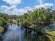 Lush backyard and pool area overlooking canal, highlighting waterfront privacy and tranquility at 18712 Lakeshore Dr, Lutz, FL 33549
