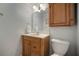Bathroom with a wooden vanity, framed mirror, overhead cabinet, and a toilet at 18712 Lakeshore Dr, Lutz, FL 33549