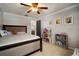 Bedroom featuring a large bed, ceiling fan, dollhouse, and neutral carpet at 18712 Lakeshore Dr, Lutz, FL 33549