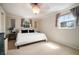 Bright bedroom with a neutral color palette, two windows, and a comfortable queen-sized bed at 18712 Lakeshore Dr, Lutz, FL 33549