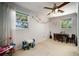 Bright bedroom with natural light, ceiling fan, playroom decor, and neutral carpet at 18712 Lakeshore Dr, Lutz, FL 33549