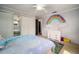 Bedroom with a bed, ceiling fan, closet doors, a rainbow wall decoration, and carpeted floors at 18712 Lakeshore Dr, Lutz, FL 33549