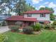 Charming two-story home featuring a red roof, well-maintained landscaping, and an attached garage at 18712 Lakeshore Dr, Lutz, FL 33549