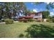 Charming two-story home showcasing lush landscaping and a well-manicured lawn at 18712 Lakeshore Dr, Lutz, FL 33549