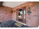 Cozy front entrance with a brick exterior and decorative hanging basket at 18712 Lakeshore Dr, Lutz, FL 33549