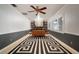 Office/den featuring custom bookshelves, ceiling fan, plush carpet and natural lighting at 18712 Lakeshore Dr, Lutz, FL 33549