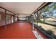 Wide screened-in patio with views of the backyard, a hot tub and wood-look floors offers a place to relax at 18712 Lakeshore Dr, Lutz, FL 33549