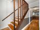 Classic wooden staircase featuring a decorative railing and hardwood flooring throughout at 18712 Lakeshore Dr, Lutz, FL 33549