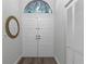 A clean, well-lit foyer has tiled flooring, a stained glass accent window, and double doors for entry at 200 Pinewinds Blvd, Oldsmar, FL 34677