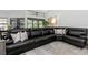An oversized sofa is featured in this well-lit room with an area rug and natural sunlight from surrounding windows at 200 Pinewinds Blvd, Oldsmar, FL 34677