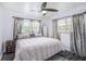 Cozy bedroom featuring a ceiling fan, windows, and a trunk side table at 202 W Azalea Ave, Tampa, FL 33612
