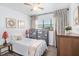 Cozy bedroom featuring a ceiling fan, window, and side tables at 202 W Azalea Ave, Tampa, FL 33612