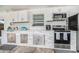 Outdoor kitchen with stone detailing, stainless steel appliances, and white cabinets at 202 W Azalea Ave, Tampa, FL 33612