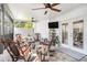 Sunroom featuring multiple rocking chairs, ceiling fans, and a mounted television at 202 W Azalea Ave, Tampa, FL 33612