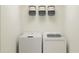 Well-lit laundry room featuring a full-size washer and dryer and overhead shelving with decorative storage baskets at 218 27Th Se St, Ruskin, FL 33570