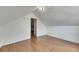 An attic room featuring wood-look flooring and a doorway, ideal for flexible living space at 2402 Harper St, Tampa, FL 33605