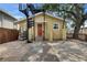 Charming yellow house with a backyard featuring a spiral staircase, brick pavers, and a fenced yard at 2402 Harper St, Tampa, FL 33605
