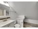 A bathroom with a white sink and toilet set against a backdrop of gray wood-look flooring at 2402 Harper St, Tampa, FL 33605