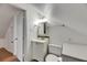 A bathroom featuring a toilet and sink, complemented by a mirror and lighting at 2402 Harper St, Tampa, FL 33605